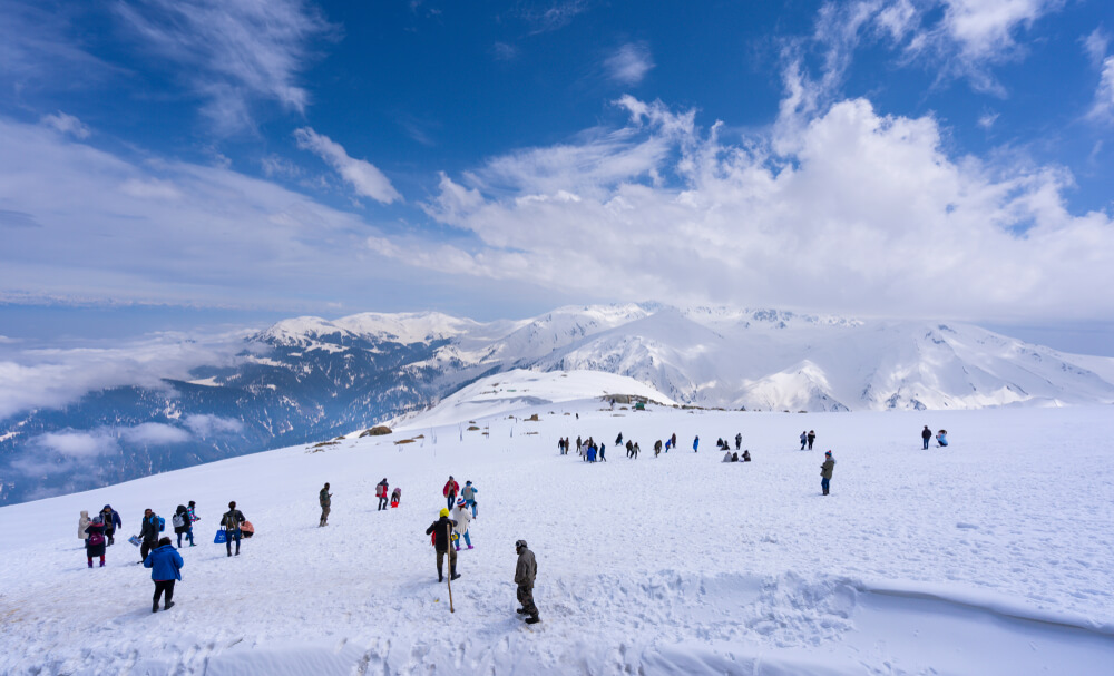 Apharwat Peak snow-covered summit with panoramic Himalayan views and skiers